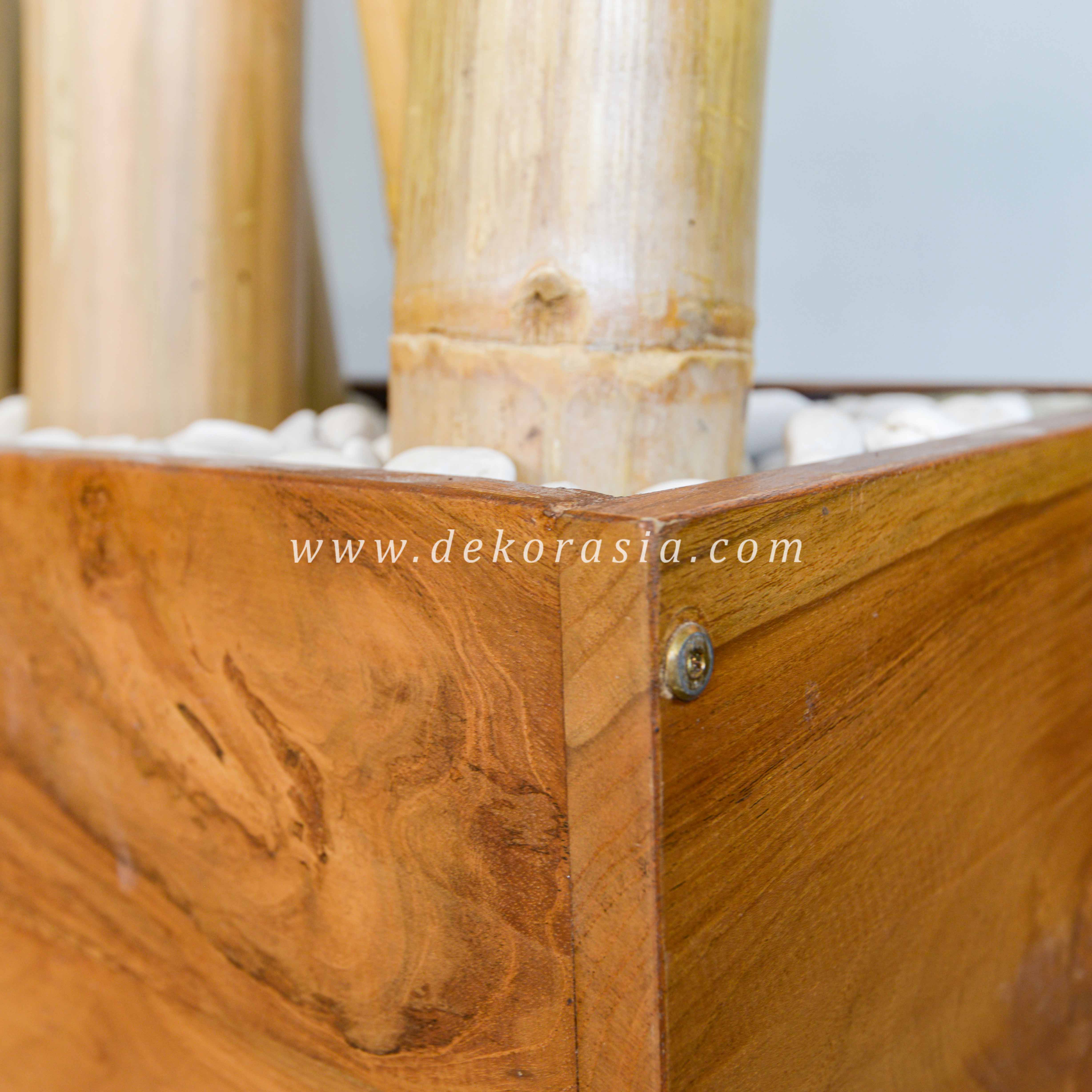 Bamboo poles on the rectangle rustic teak pot with pebbles